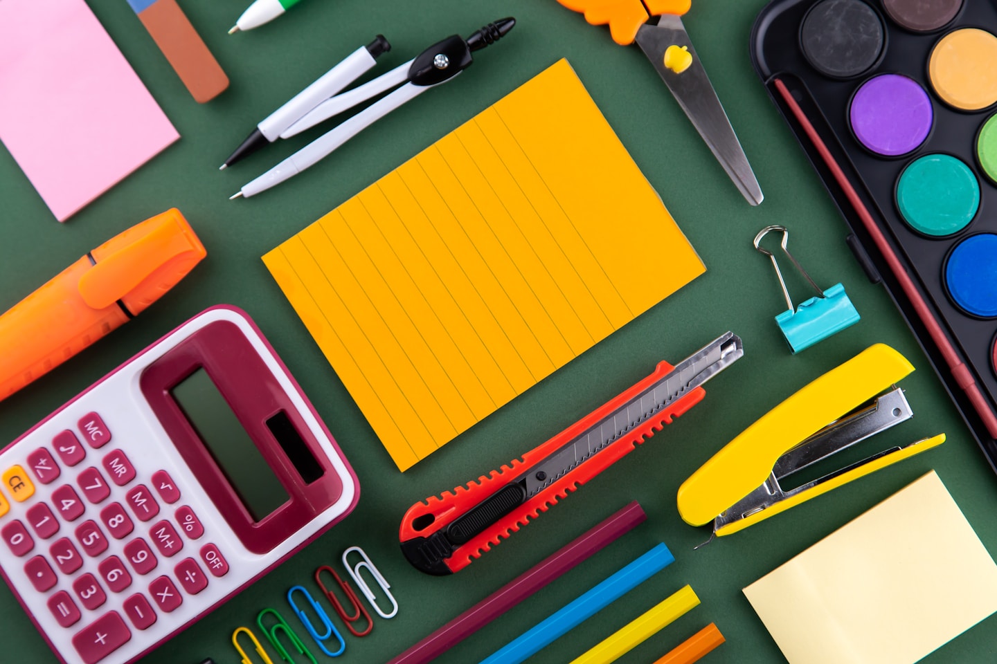 School office supplies stationery on a purple background desk with copy space. Back to school concept.